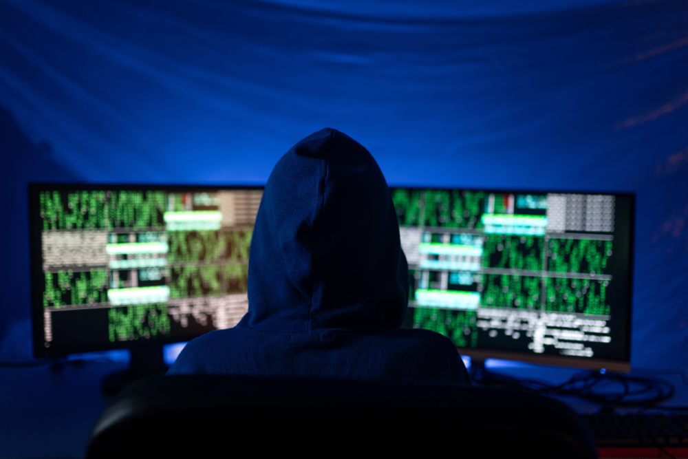 Hooded person representing common cyberattacks