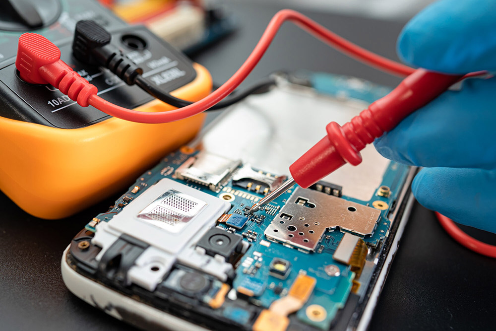 Technician performing micro-level phone repair to recover digital evidence in a forensic investigation